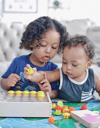 Siblings playing with the Mosaic Button Board from The Companion Play Kit